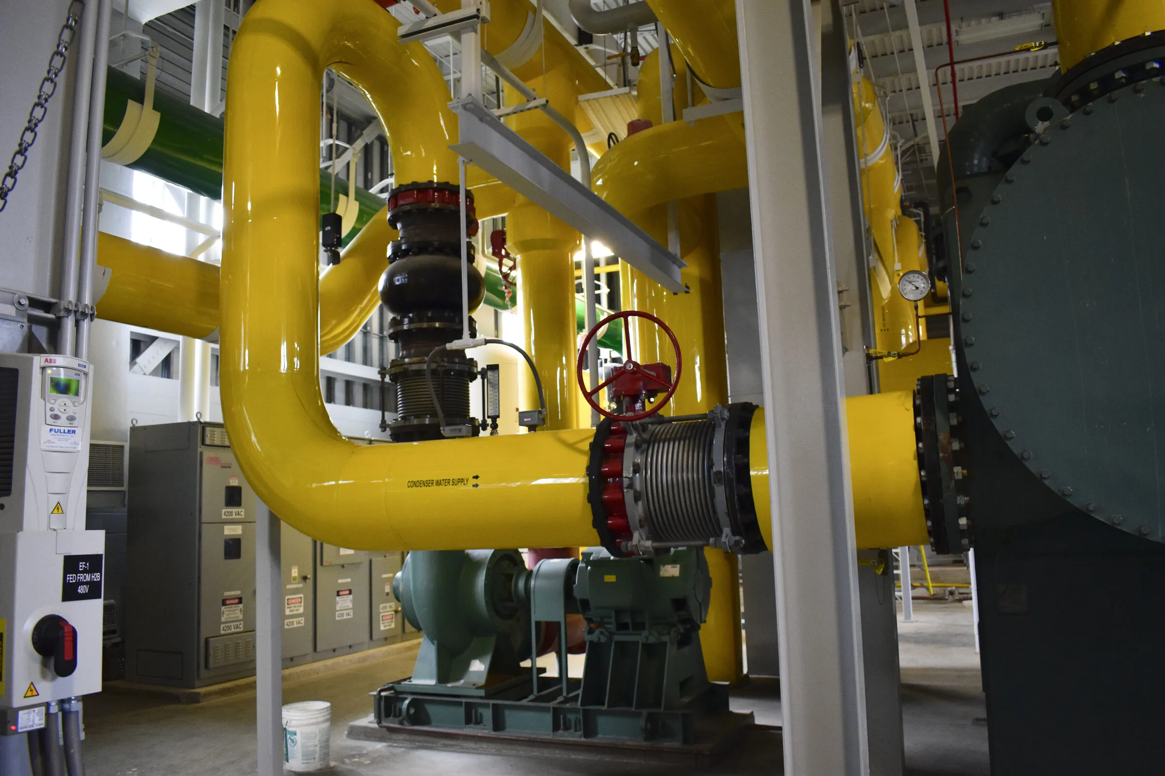 Yellow pipework, valves and pumps in the ground-source heat pump plant that heats and cools Ball State University in Indiana.