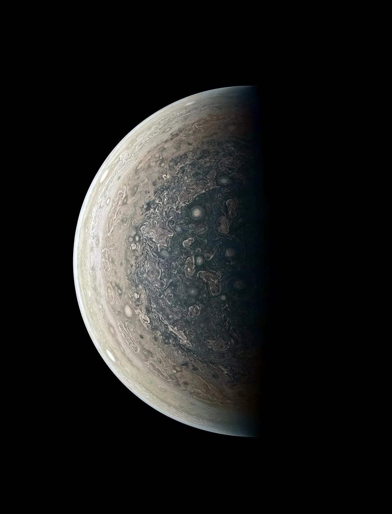 A crescent Jupiter with swirling cloud bands.