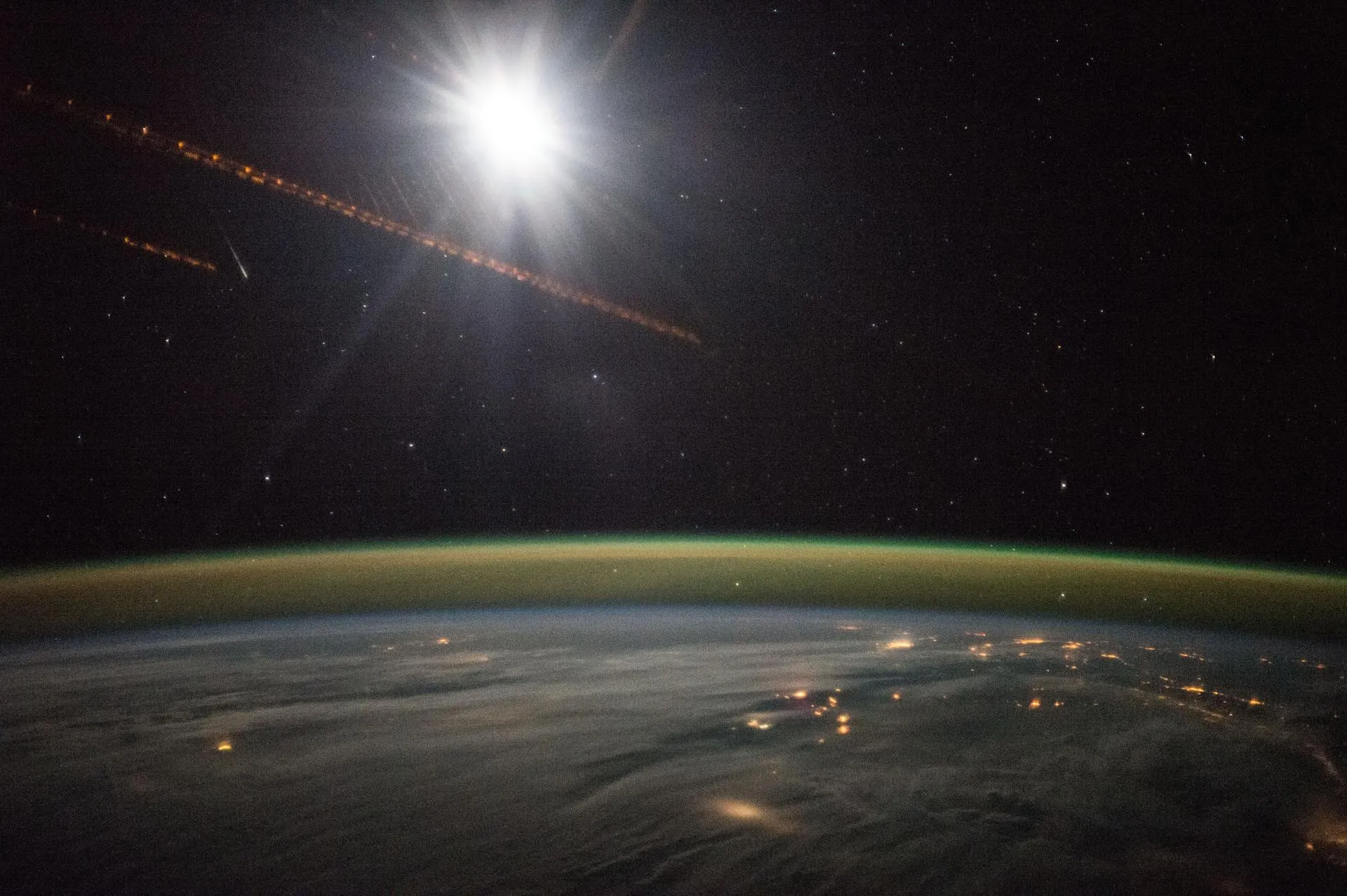 City lights and the Moon over the night side of Earth.