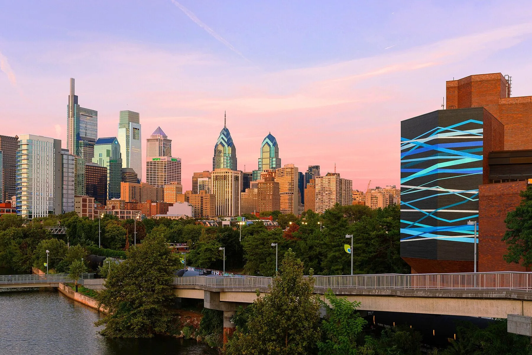 A nagy absztrakt falfestmény kék fénycsíkokban egy épület oldalán a Schuylkill folyó mellett Philadelphiában.